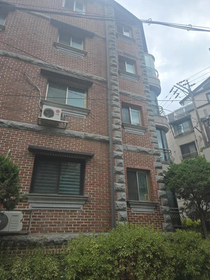 언덕 배경의 오래된 벽돌 건물 외관 전경 사진